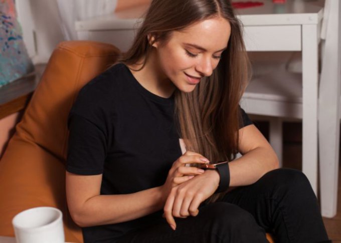 Kobieta zmienia tapetę w swoim smartwatchu