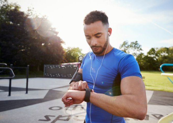 Mężczyzna w trakcie biegania sprawdza swojego smartwatcha